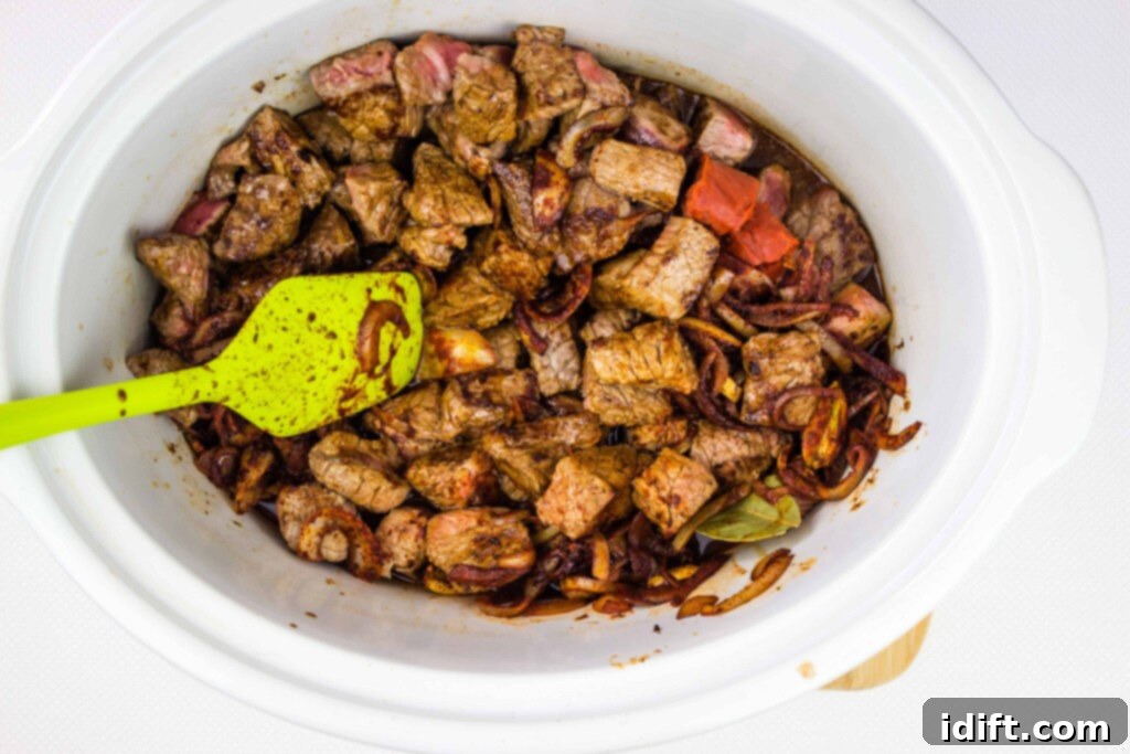 Hearty Hungarian Goulash 8 All ingredients, including browned beef, sautéed onions, spices, broth, and tomato paste, combined in a crockpot, ready for slow cooking to create an authentic Hungarian goulash.