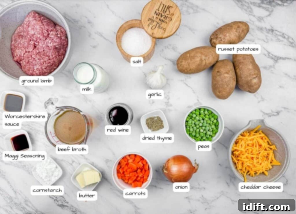 Ingredients for Shepherd’s Pie Baked Potatoes displayed on a marble surface, including ground lamb, potatoes, peas, carrots, onion, garlic, cheddar cheese, milk, butter, red wine, broth, seasonings, and salt.