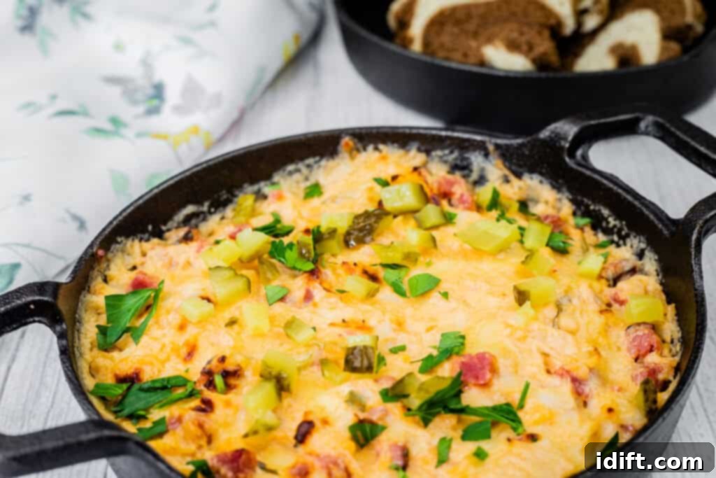 Golden Baked Reuben Dip 8 Cheesy, golden-brown Hot Reuben dip in a cast-iron skillet, topped with chopped pickles and fresh parsley, served on a slate board with sliced brown bread.