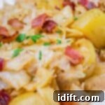 Savory sautéed Cabbage & Potatoes with Bacon, garnished with fresh parsley on a white serving dish.