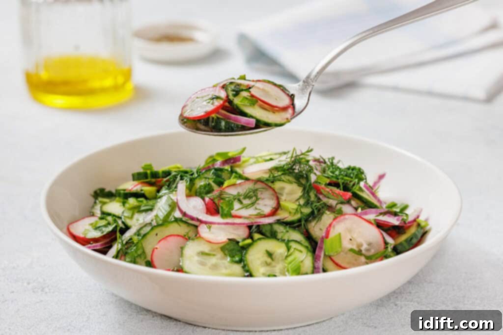 A bowl of Radish Salad garnished with herbs. A spoon holds a portion above the bowl.