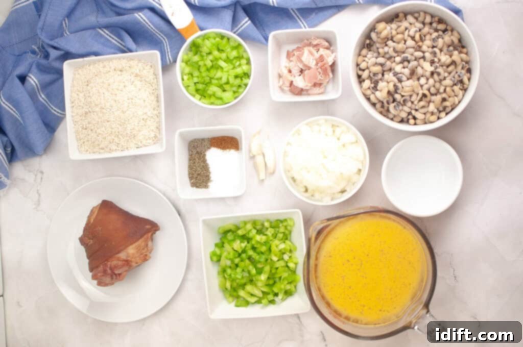Overhead view of bowls containing rice, chopped celery, chopped onions, black-eyed peas, ham, seasonings, garlic, water, and broth on a white surface with a blue cloth.