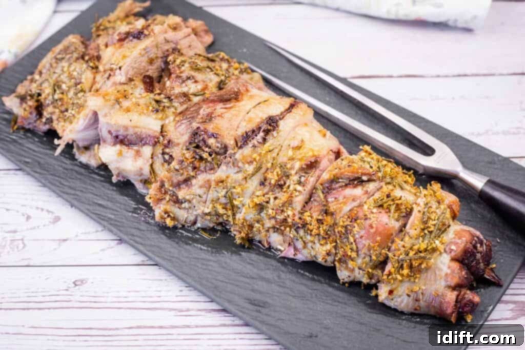 Aromatic Slow-Roasted Lamb Leg 3 A black platter with artfully sliced, roasted leg of lamb, garnished with fresh herbs, ready for serving.