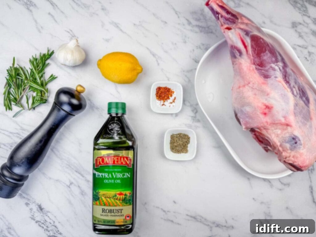 Aromatic Slow-Roasted Lamb Leg 5 Overhead shot of ingredients for roast leg of lamb, including a leg of lamb, olive oil, lemon, garlic, rosemary, and spices, laid out on a clean surface.