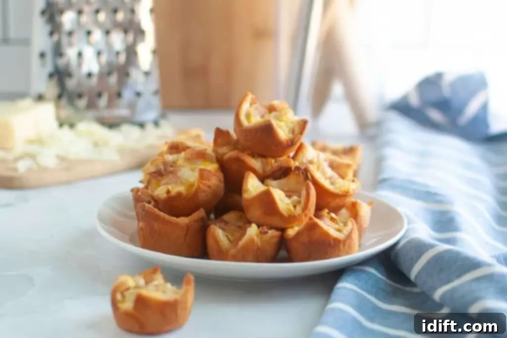 Fluffy Ham and Cheese Bites 11 A white plate generously piled with small, golden-brown Ham and Cheese Puffs, perfect for serving at a party or brunch.