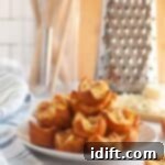 Fluffy Ham and Cheese Bites 12 A white plate piled with small, golden-brown Ham and Cheese Puffs.