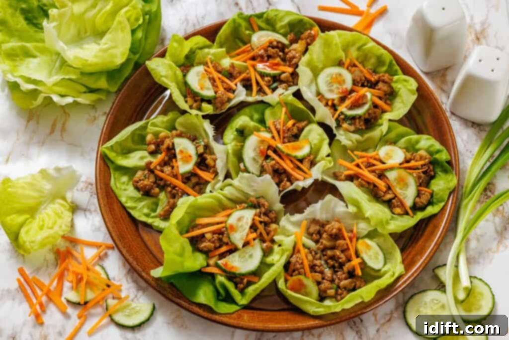 Lettuce wraps with meat and vegetables on a white table.