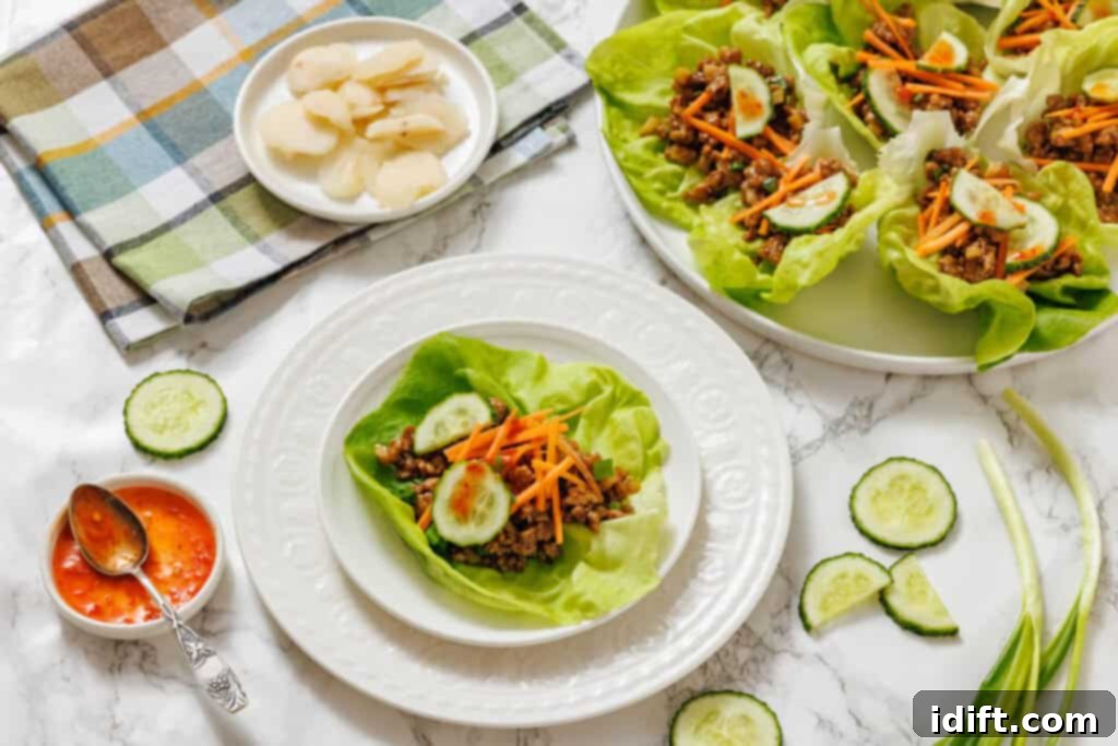 Lettuce wraps with meat and vegetables on a white table.