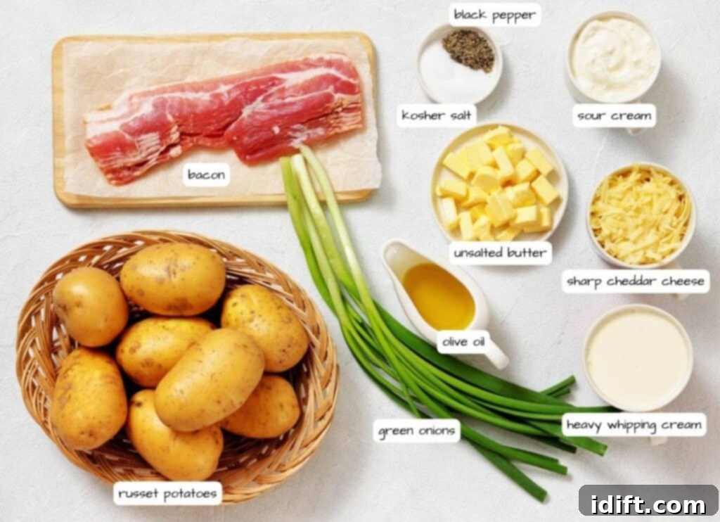 A variety of ingredients are arranged on a countertop, including russet potatoes, bacon, green onions, olive oil, unsalted butter, black pepper, kosher salt, sour cream, cheddar cheese, and heavy cream.
