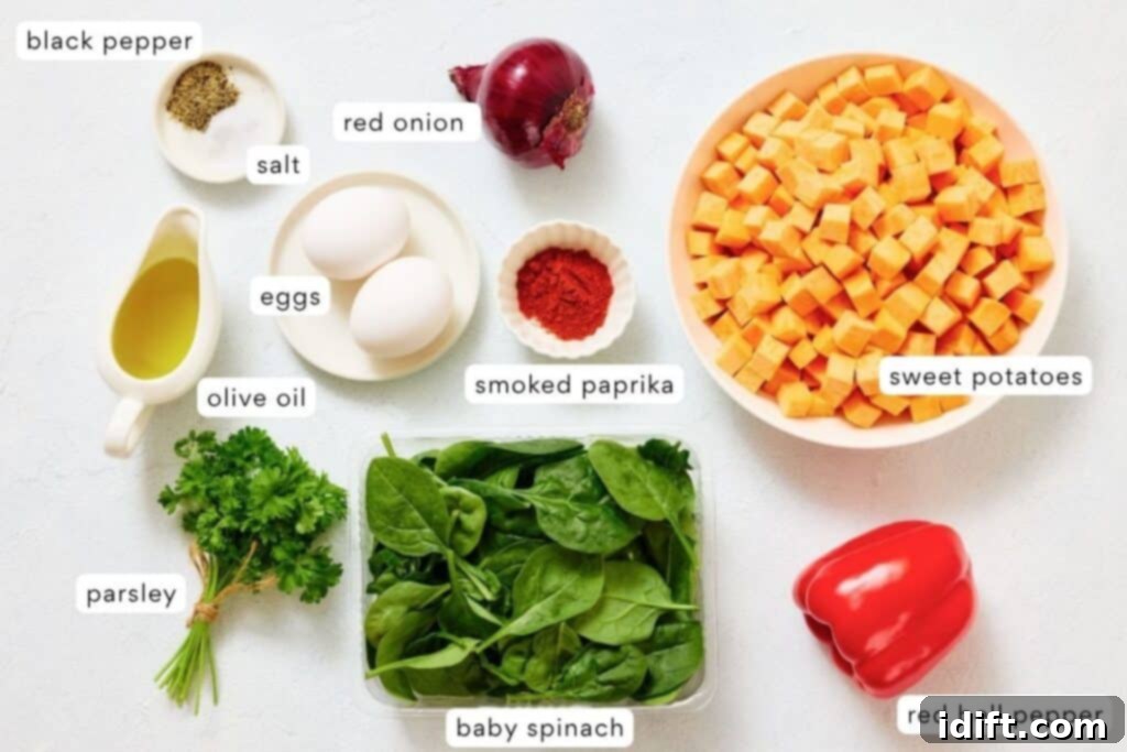 Golden Sweet Potato and Spinach Hash 4 A variety of labeled ingredients on a white surface, including sweet potatoes, eggs, red onion, red bell pepper, baby spinach, parsley, olive oil, salt, black pepper, and smoked paprika. Each ingredient is fresh and neatly arranged, highlighting their natural colors and textures.