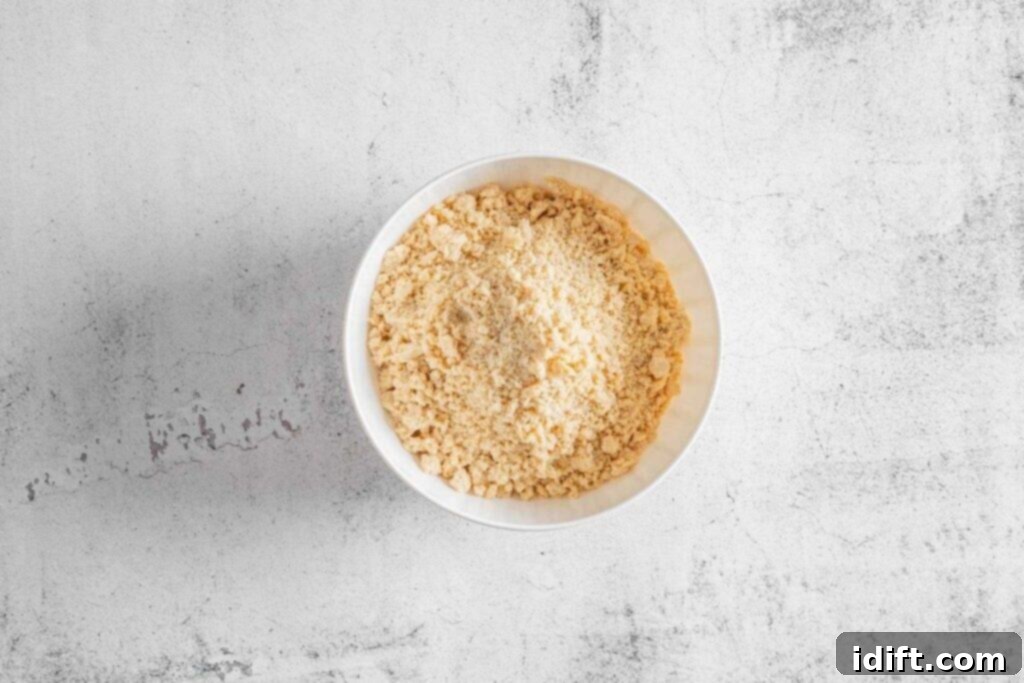 A white bowl filled with mixture sits on a light gray textured surface.