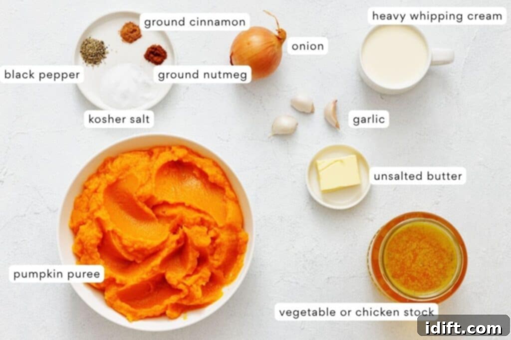 A beautifully arranged selection of ingredients for creamy pumpkin soup laid out on a clean white surface. Key items include a can of pumpkin puree, various warm spices in small bowls, a whole onion, fresh garlic cloves, a stick of butter, a carton of heavy cream, and a container of vegetable broth.