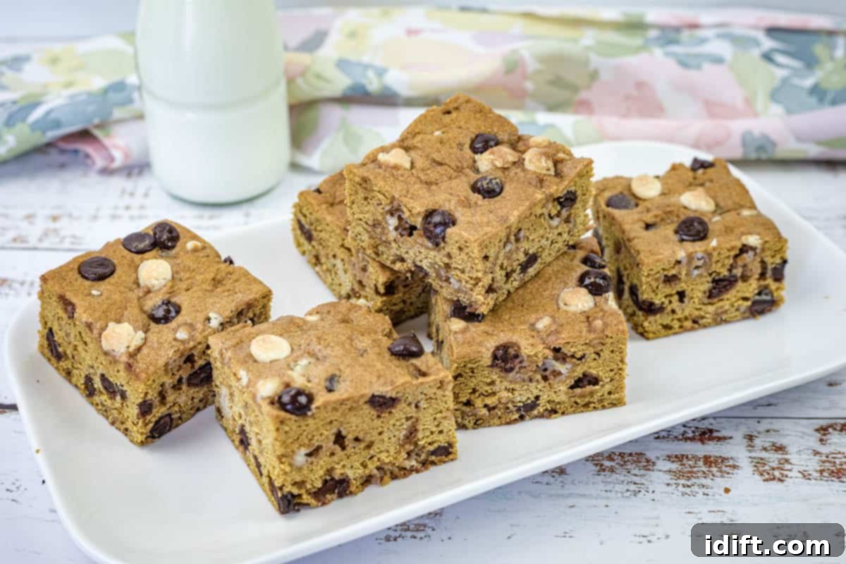 21 Halloween Bites So Good They'll Vanish Before Any Costume Compliments 4 A white rectangular plate with pieces of pumpkin blondies.