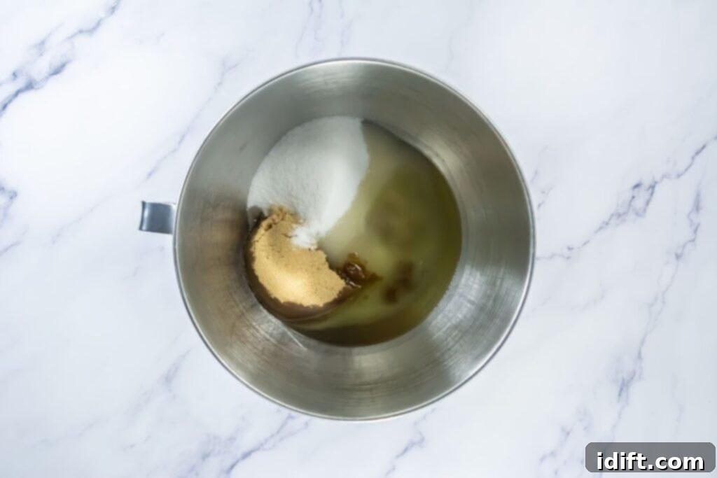 Mixing bowl with white sugar, brown sugar, and oil, ready to be mixed.