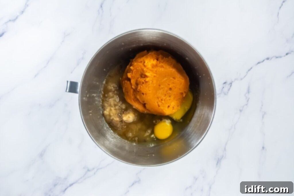 Mixing bowl with pumpkin puree, eggs, and other wet ingredients before combining.