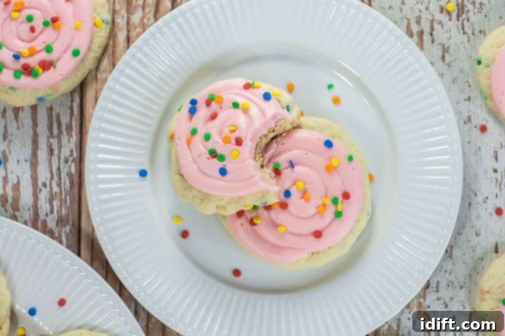 A beautifully arranged plate of pink frosted confetti cake cookies, ready to be served.