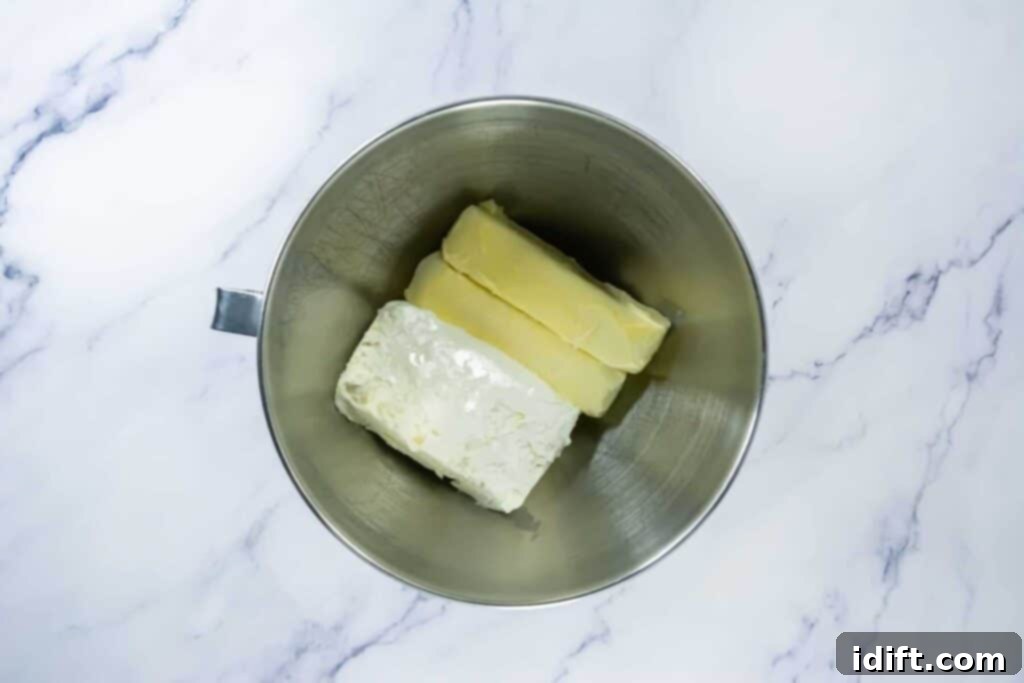 Softened butter and cream cheese in a metal stand mixer bowl, ready for frosting.