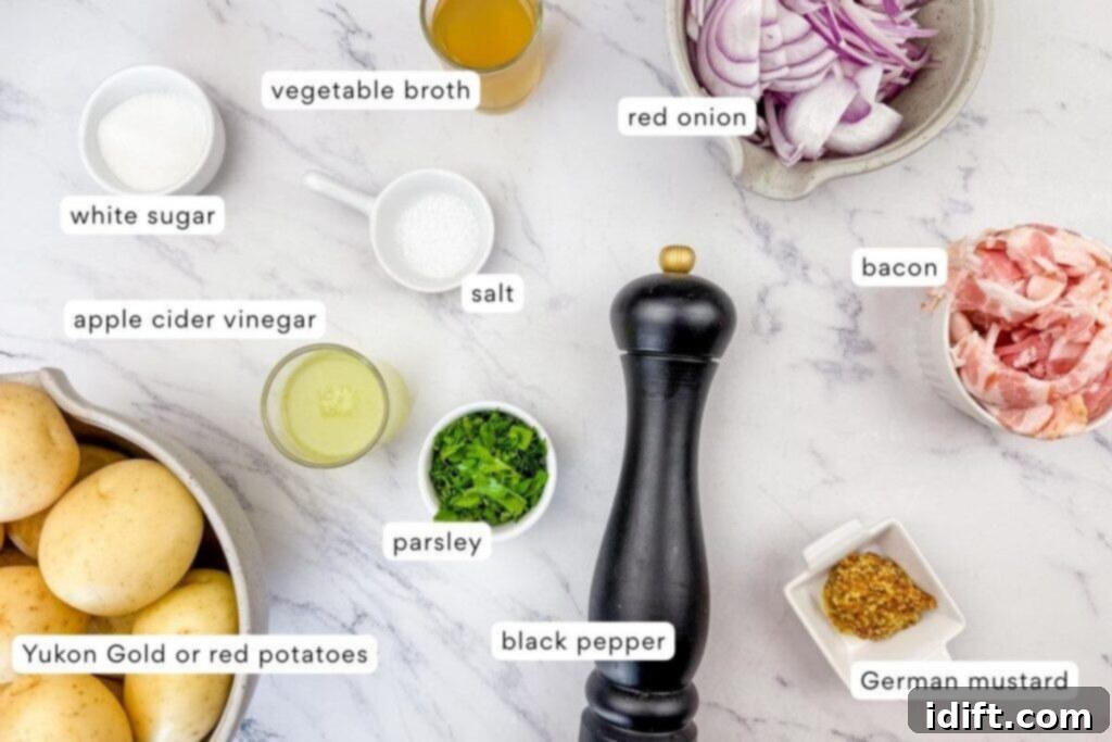 Ingredients for German potato salad are arranged on a marble surface, including potatoes, bacon, red onion, parsley, mustard, vinegar, vegetable broth, white sugar, salt, and black pepper.