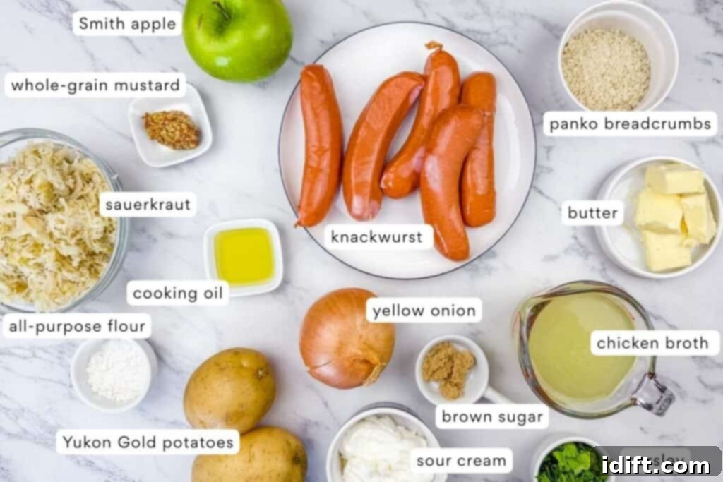 A variety of labeled ingredients on a marble surface, including knackwurst, potato, apple, breadcrumbs, sauerkraut, mustard, onion, butter, and various seasonings.