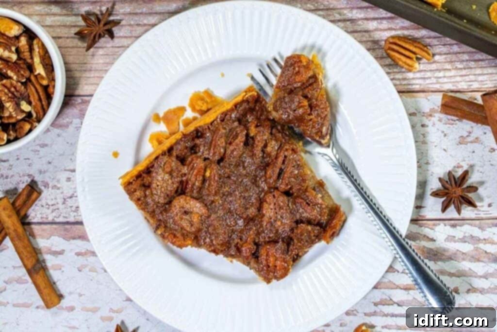 Slice of pecan slab pie on a white plate surrounded by spices