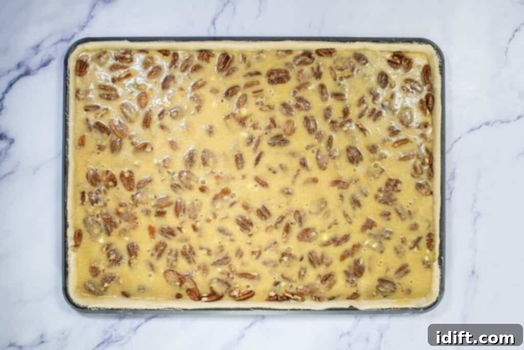 Filling poured over pecans in baking sheet