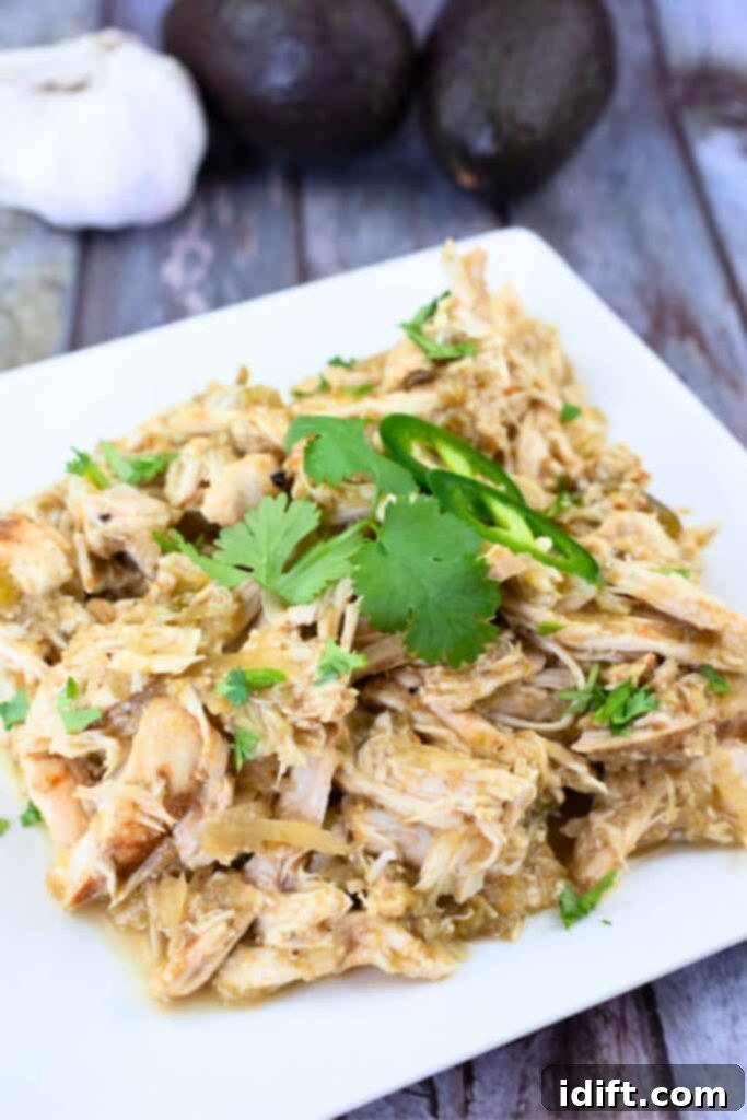 Close-up of Slow Cooker Hatch Chili Salsa Chicken garnished with cilantro and jalapeños