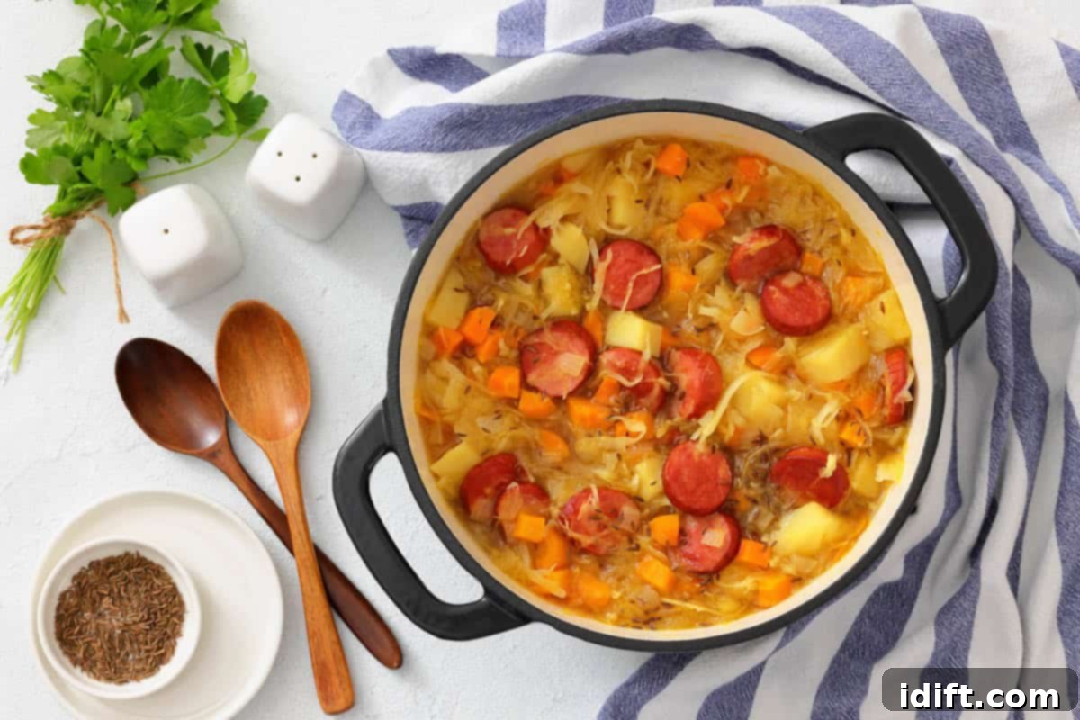 Timeless Kitchen Treasures: Rediscovering Vintage Recipes 2 A delicious pot of Chef Jenn’s Sauerkraut Soup with Kielbasa, garnished with fresh herbs and served with wooden spoons.