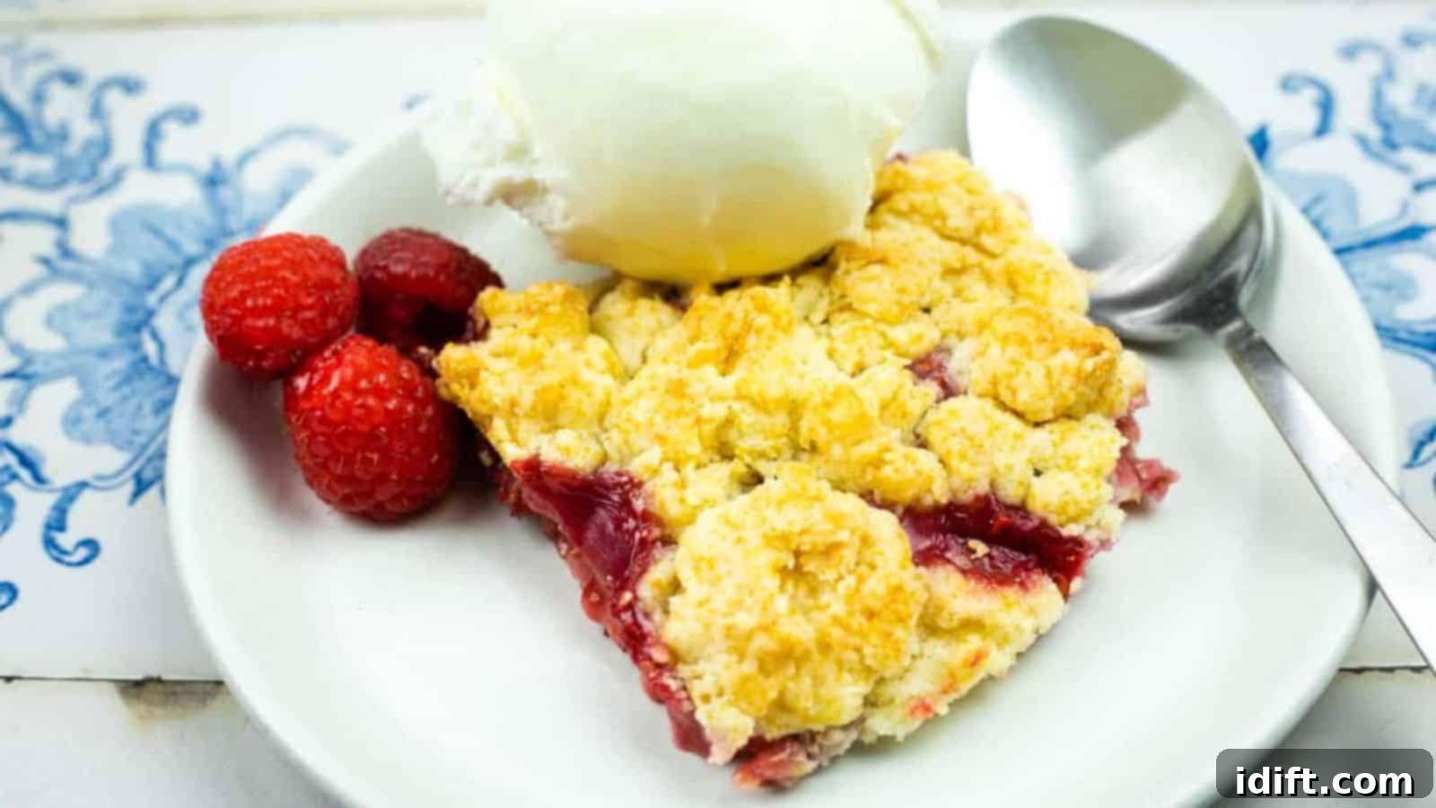 Timeless Kitchen Treasures: Rediscovering Vintage Recipes 5 A warm slice of Raspberry Cobbler With Fresh, Juicy Berries and Buttery Biscuit Topping, topped with a scoop of vanilla ice cream.
